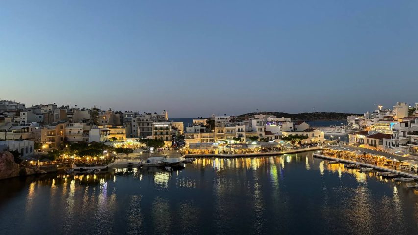 Evening view of Agios Nikolaos harbor in Crete with illuminated waterfront